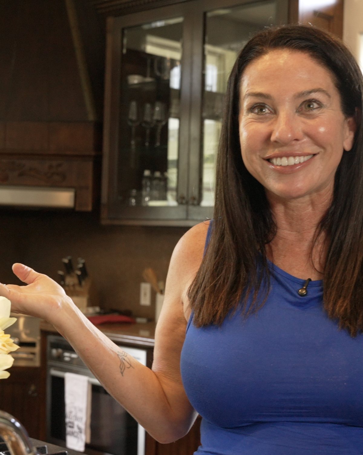 Ava Malazian in a blue top, smiling in the kitchen