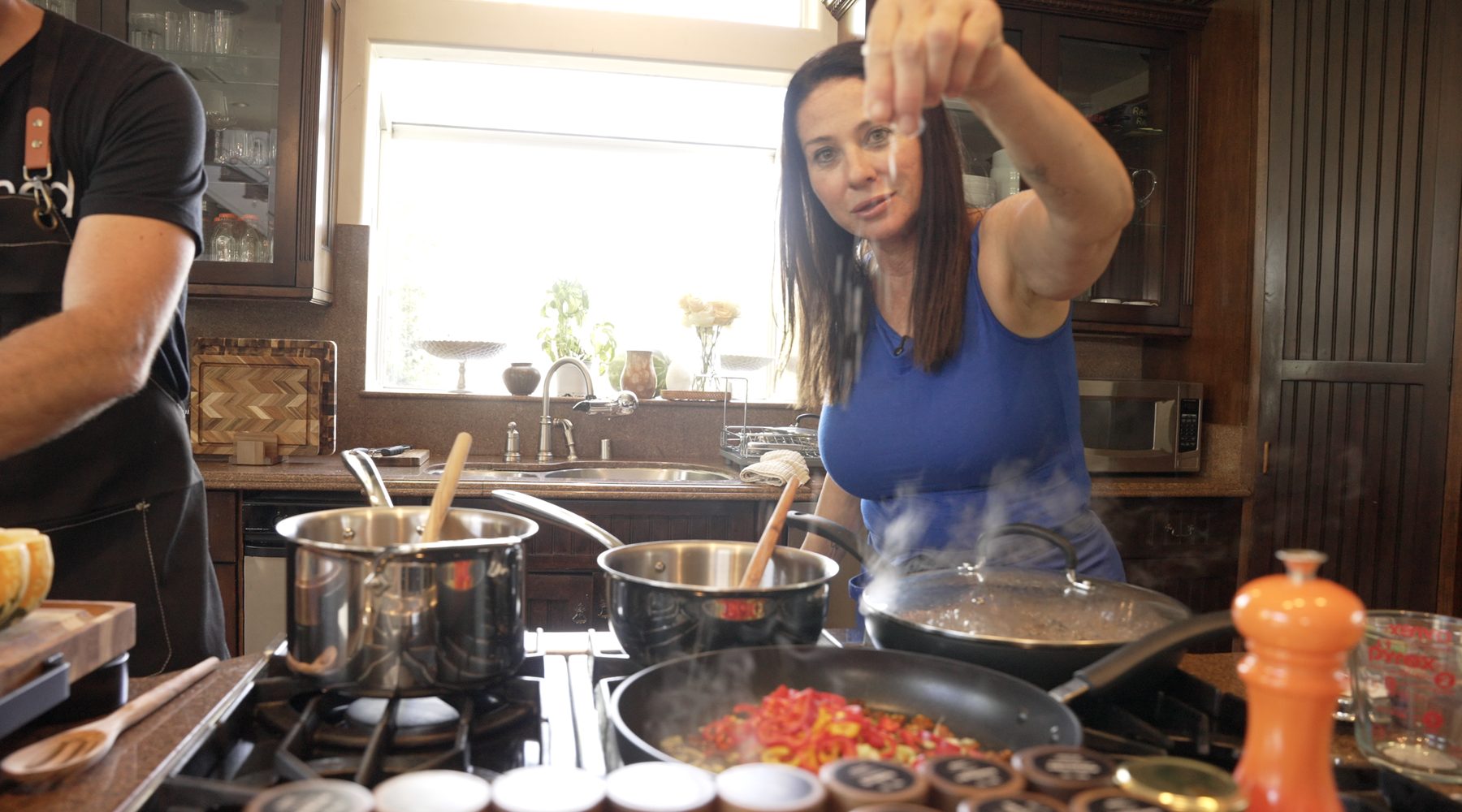 Ava Malazian seasoning a pan at the stove in a frame from The Quiet Ingredient